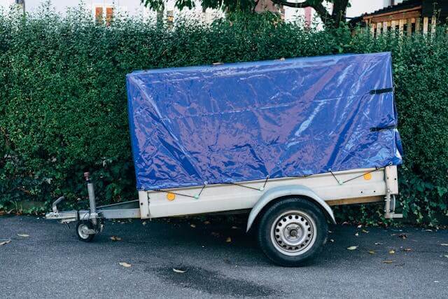 trailer covered in a secured blue tarpaulin